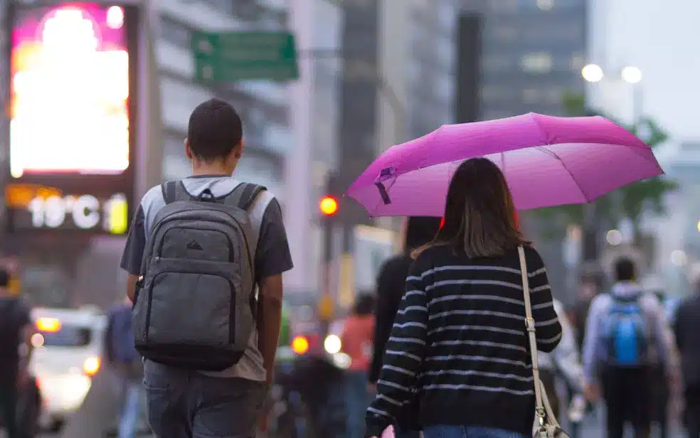 Imagem de pessoas na chuva em SP com guarda-chuva