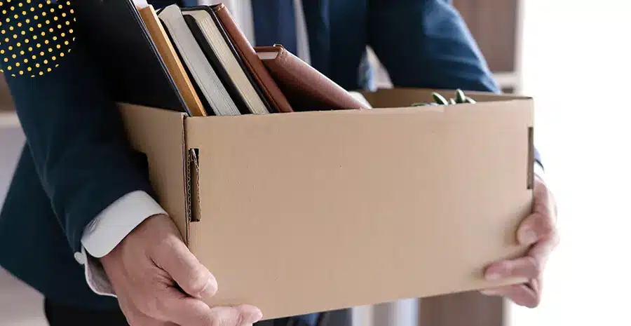 Homem segurando caixa com materiais de escritório