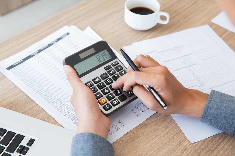 Pessoas fazendo contas para saber se o negócio é rentável.