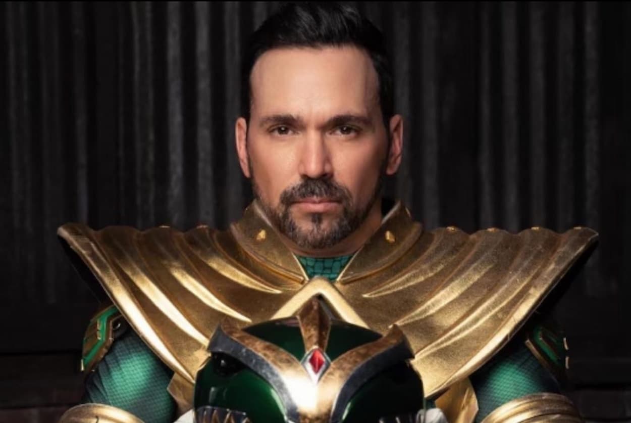 Imagem de ator de Power Ranger com o uniforme e segurando o capacete
