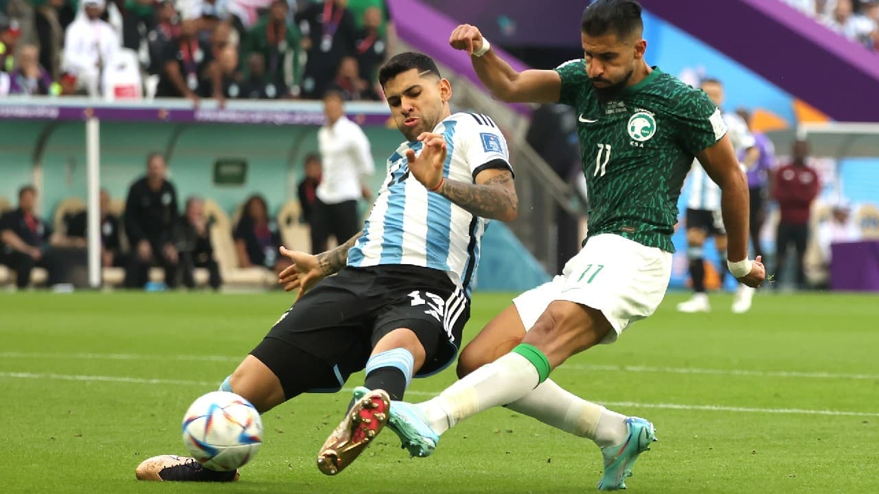 Imagem dos jogadores da Argentina e da Arábia Saudita disputando pela posse de bola em jogo da Copa do Mundo