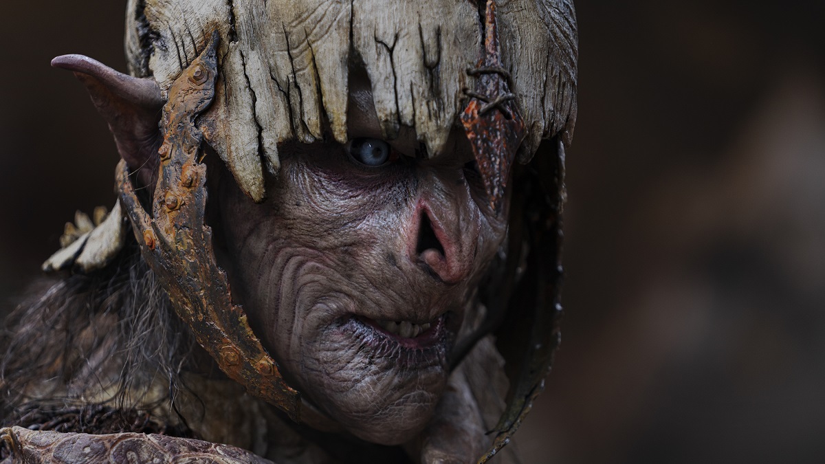 Orc horrendo encarando à frente de si em Anéis de Poder