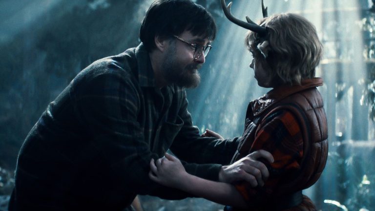Imagem retirada do série Sweet Tooth mostrando Gus sendo segurado pelos braços por um homem com barba